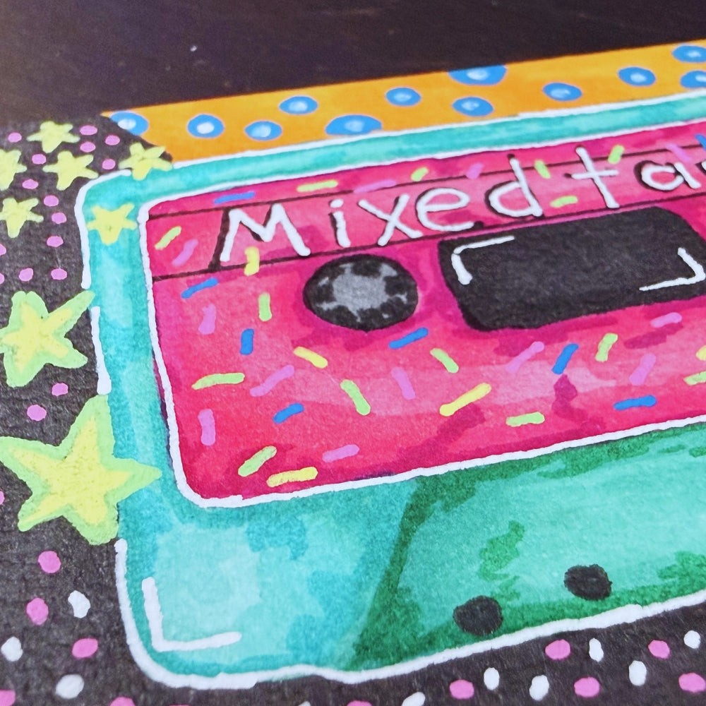 Colorful illustration of a cassette tape labeled 'Mixed Tape' with star and dot patterns on a black background.