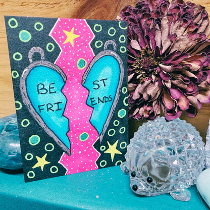 Colorful card with 'Best Friends' design on a table with decorative items.