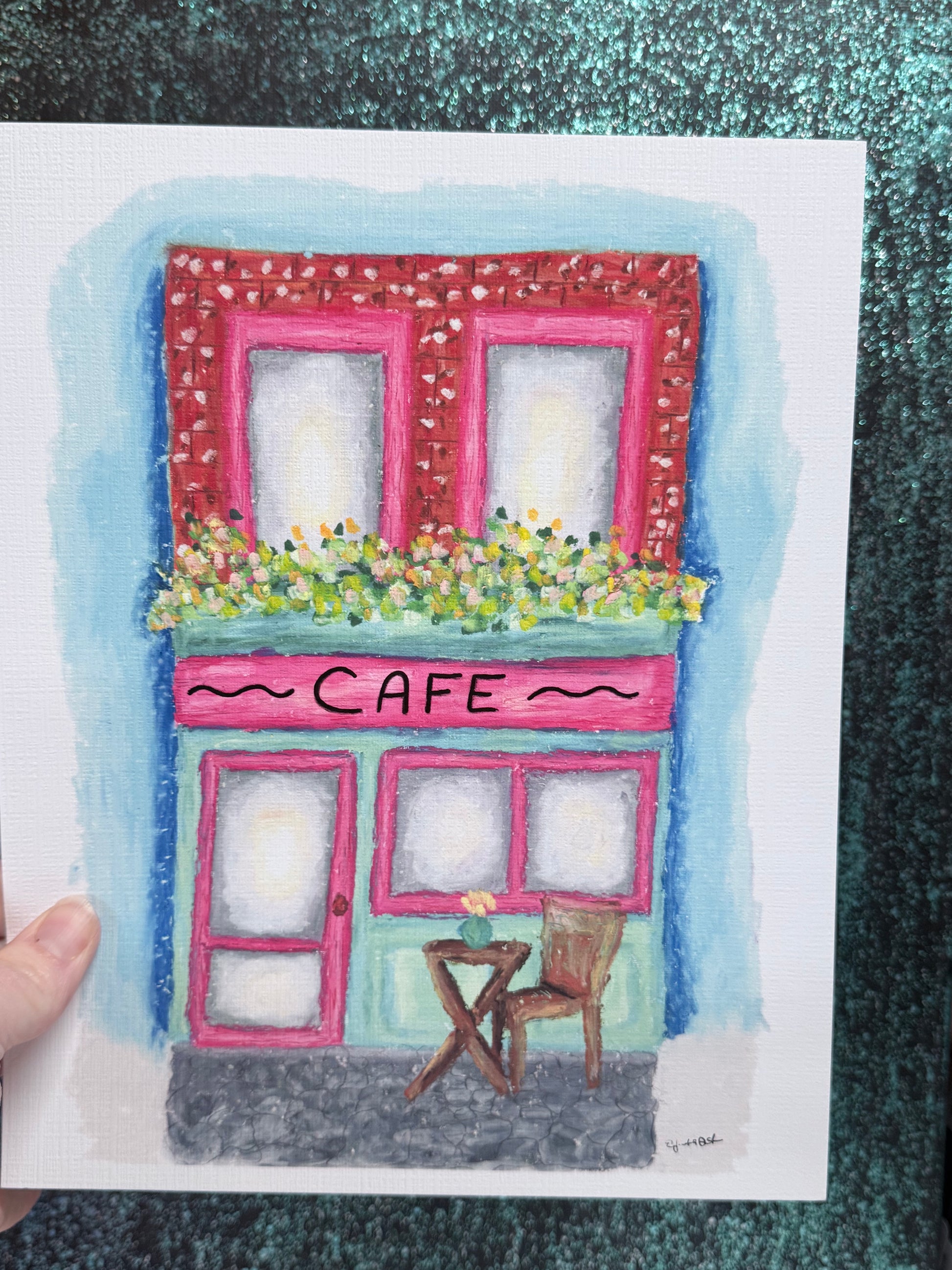 Illustration of a cafe with pink windows and a small table outside.