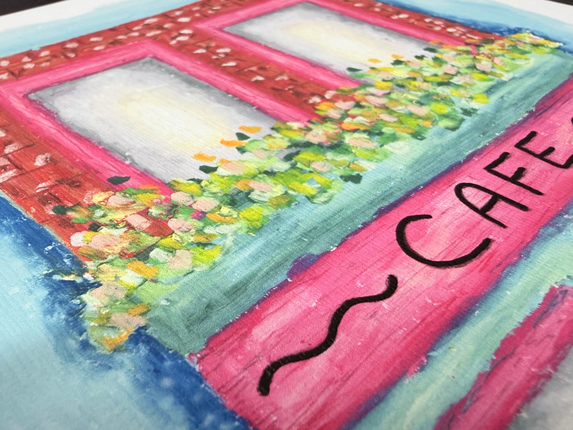 Colorful drawing of a cafe window with flowers and 'CAFE' text.
